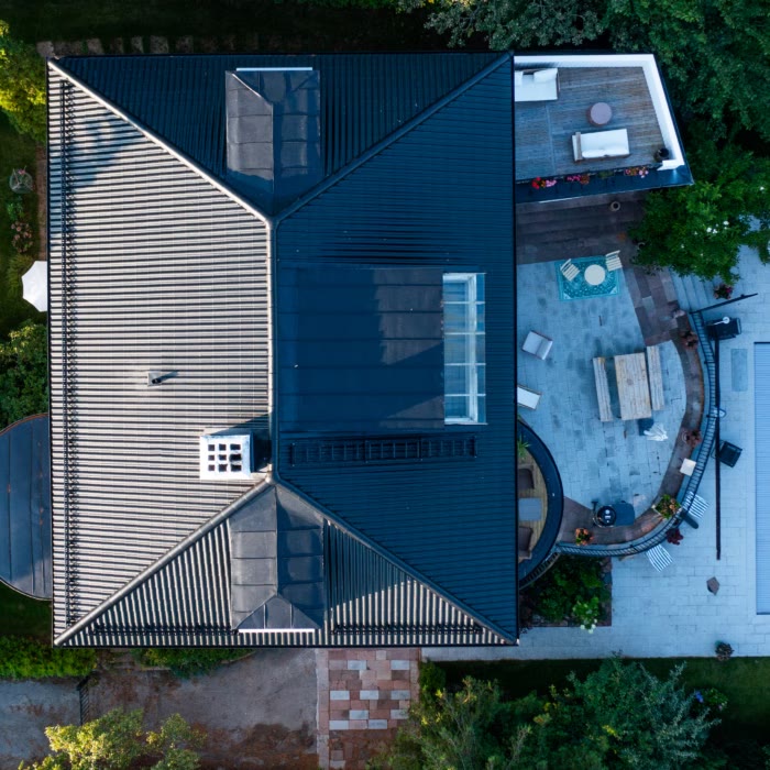 Villa med svart tak och takfönster sedd rakt ovanifrån